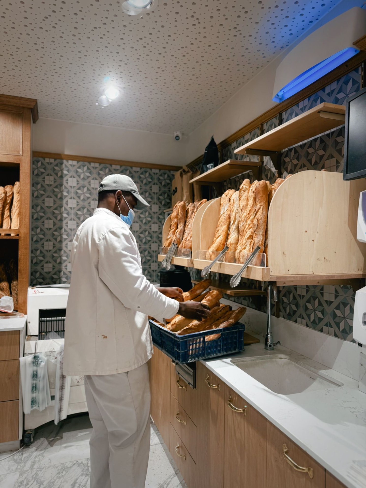 Boulanger disposant les baguettes fraîches en boutique